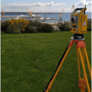 Bornage et délimitation foncière - Théodolite installé sur un site côtier pour des relevés topographiques, permettant des mesures précises des limites de terrain en bordure de port.